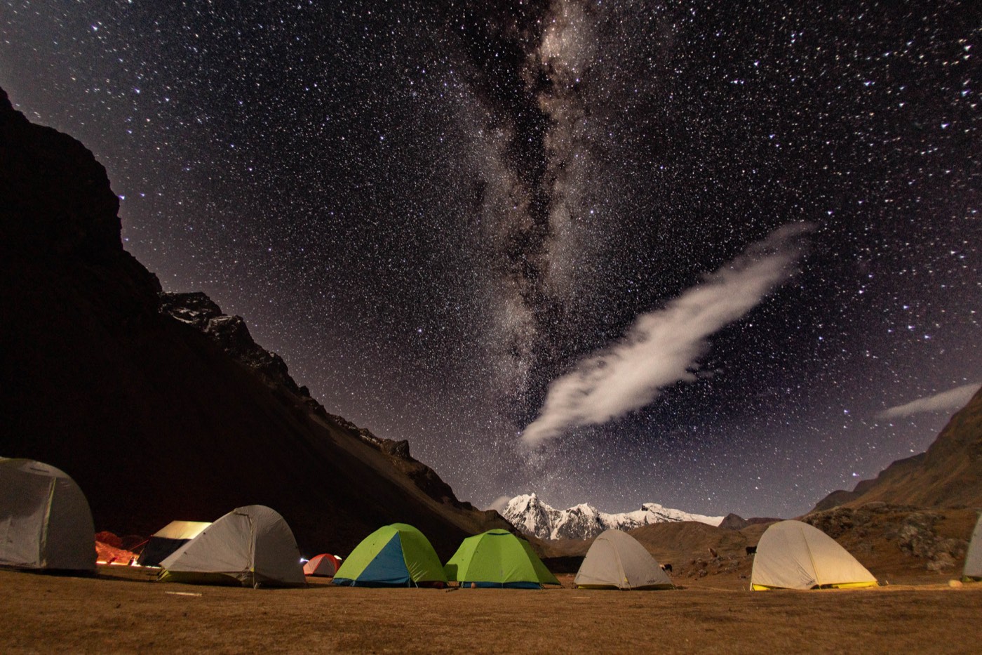 Campamento iluminado bajo la Vía Láctea y las cumbres del Ausangate.