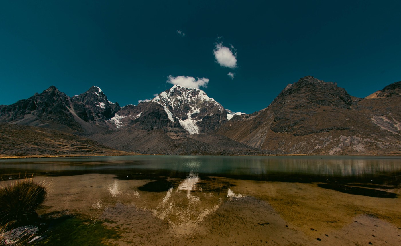 Laguna de altura refleja la cordillera bajo un cielo azul profundo.