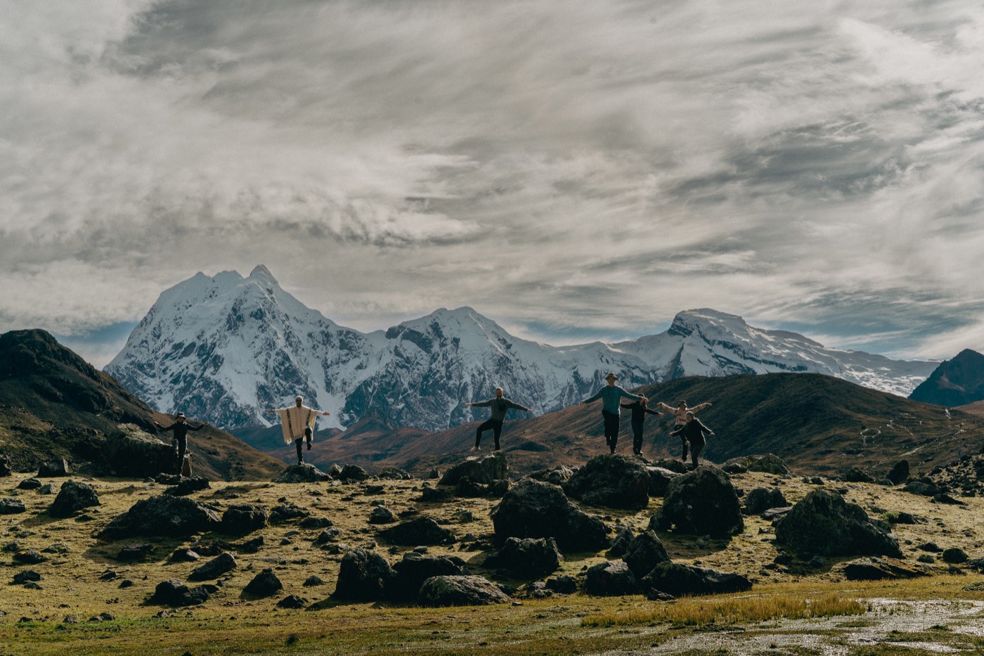 El grupo practica Chi Kung entre rocas con la cordillera nevada al fondo.