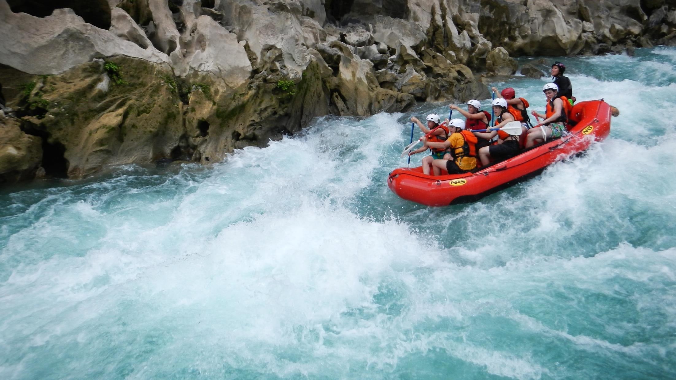 Un equipo coordina sus movimientos durante un descenso en rafting.