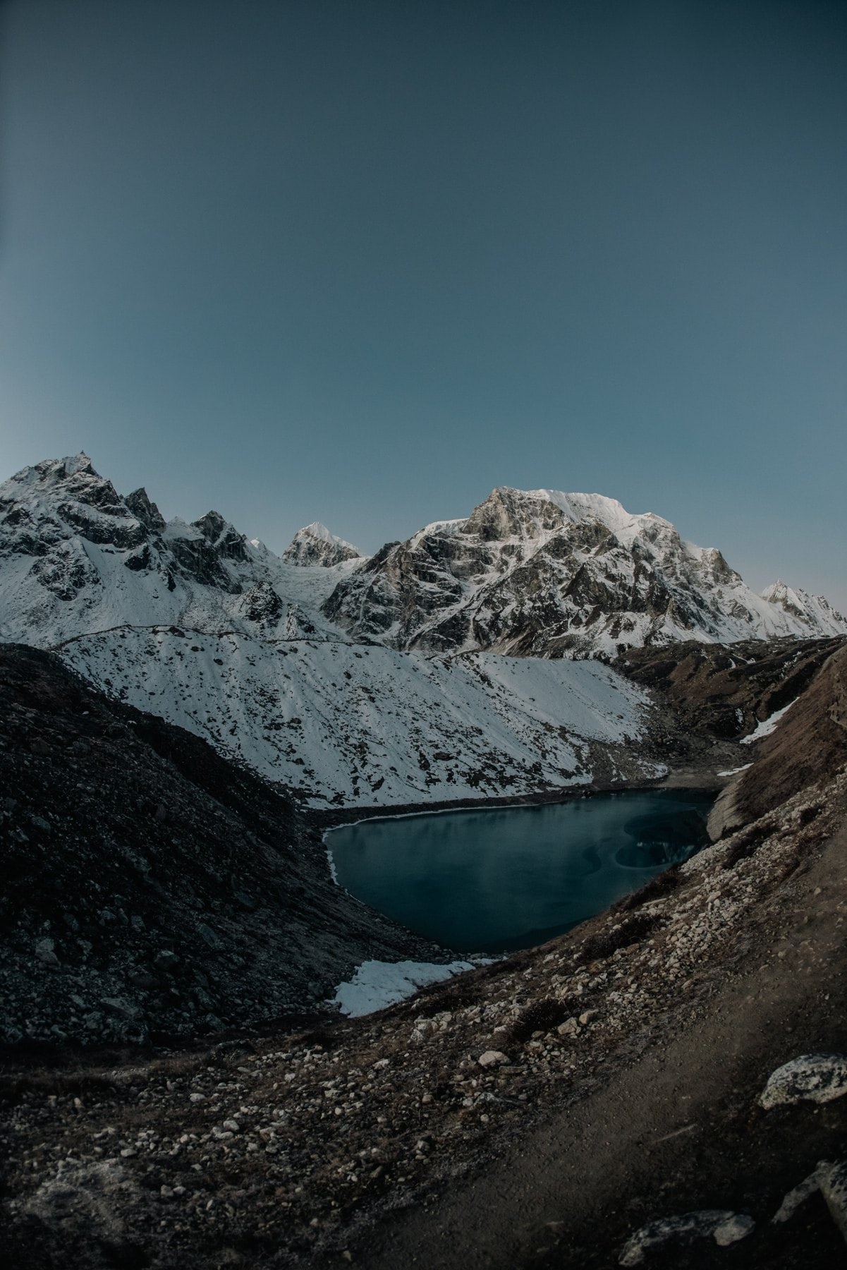 Laguna azul rodeada de nieve y roca